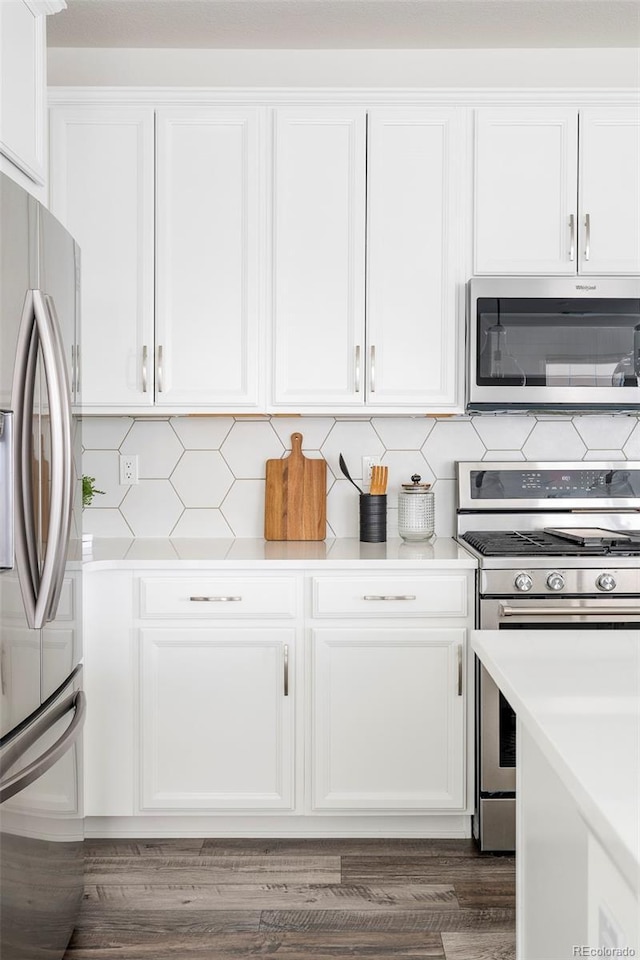 kitchen featuring stainless steel appliances, white cabinets, and light countertops