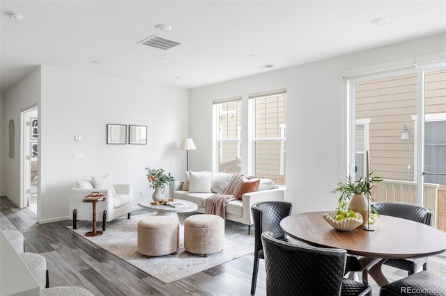 living room with visible vents, baseboards, and wood finished floors