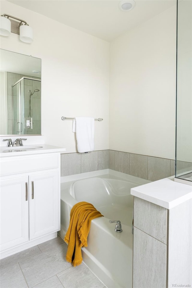 full bathroom featuring tile patterned flooring, vanity, a bath, and a stall shower