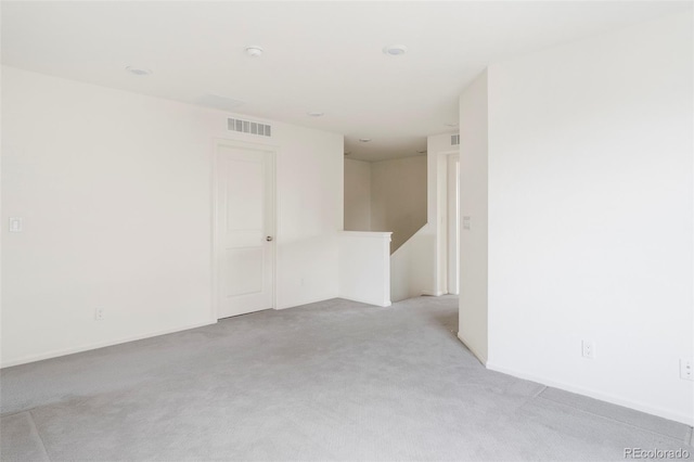 empty room with visible vents, light colored carpet, and baseboards