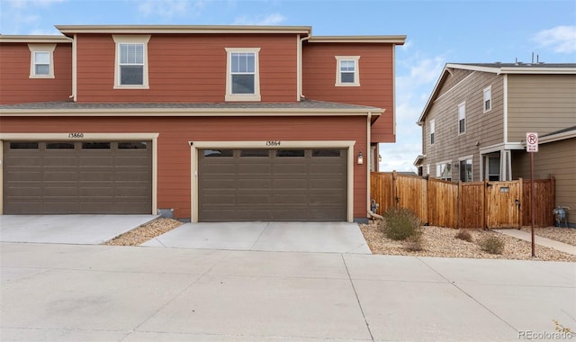 view of front of home with a garage, driveway, and fence