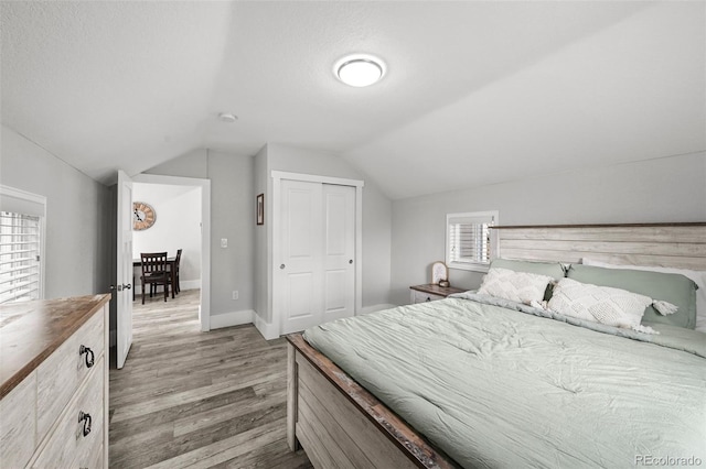 800 S Krameria St, Denver, CO 80224 - bedroom featuring light wood-style flooring, vaulted ceiling, a closet, and baseboards