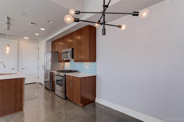 kitchen featuring hanging light fixtures, stainless steel appliances, tasteful backsplash, and sink