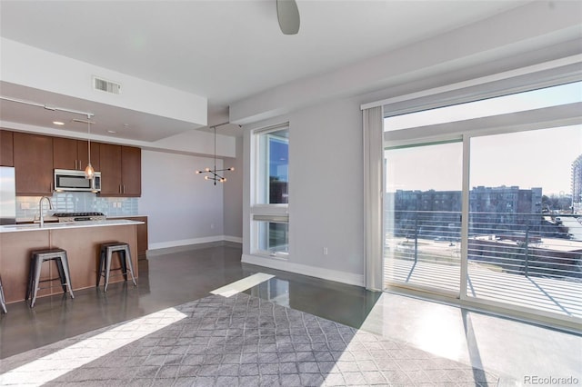 kitchen featuring a breakfast bar, plenty of natural light, backsplash, and appliances with stainless steel finishes