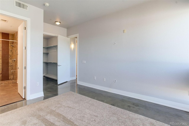 unfurnished bedroom featuring a walk in closet and a closet