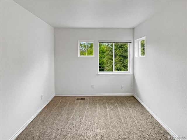 carpeted spare room featuring baseboards