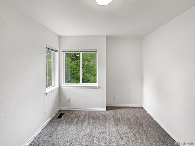 unfurnished room featuring carpet and baseboards