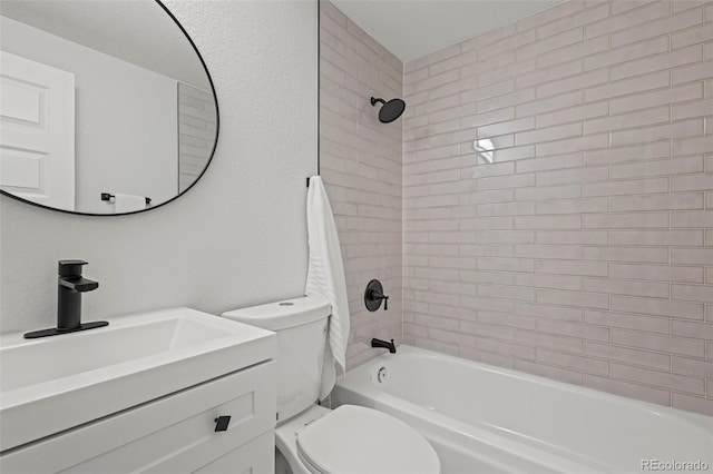 full bathroom featuring vanity, tiled shower / bath combo, and toilet