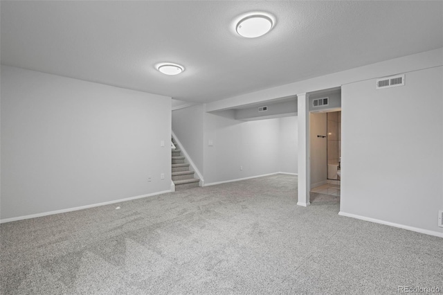 basement featuring carpet floors and a textured ceiling