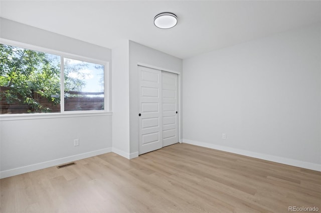 unfurnished bedroom with light hardwood / wood-style flooring and a closet