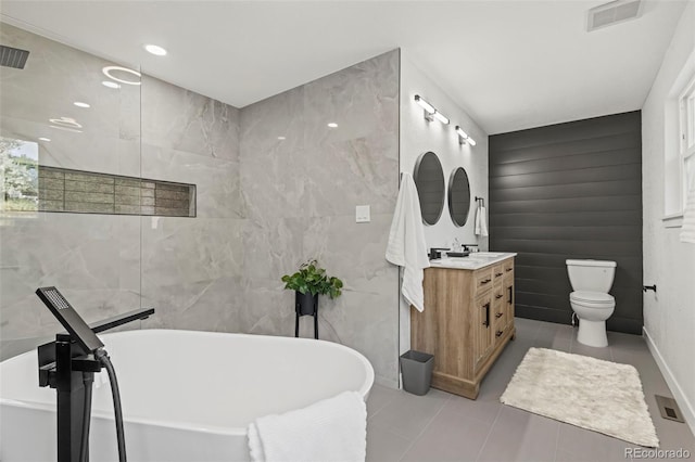 bathroom featuring vanity, tile patterned floors, a bathtub, and toilet