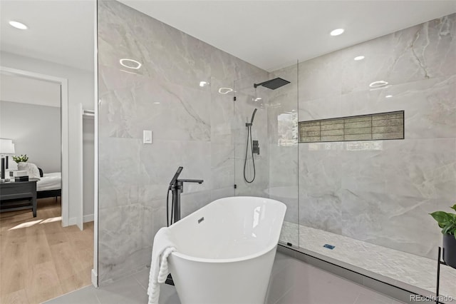 bathroom featuring tile walls, tile patterned floors, and shower with separate bathtub