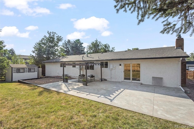 rear view of house with a storage shed, a yard, and a patio area