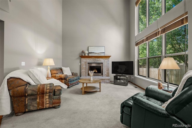 6285 Moccasin Pass Ct, Colorado Springs, CO 80919 - living room featuring carpet flooring, a towering ceiling, and a brick fireplace