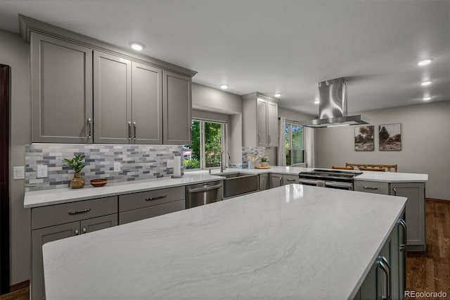 6285 Moccasin Pass Ct, Colorado Springs, CO 80919 - kitchen with gray cabinetry, island range hood, stainless steel appliances, a peninsula, and dark wood-style flooring