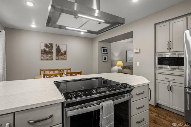 6285 Moccasin Pass Ct, Colorado Springs, CO 80919 - kitchen with stainless steel appliances, range hood, light countertops, gray cabinetry, and recessed lighting