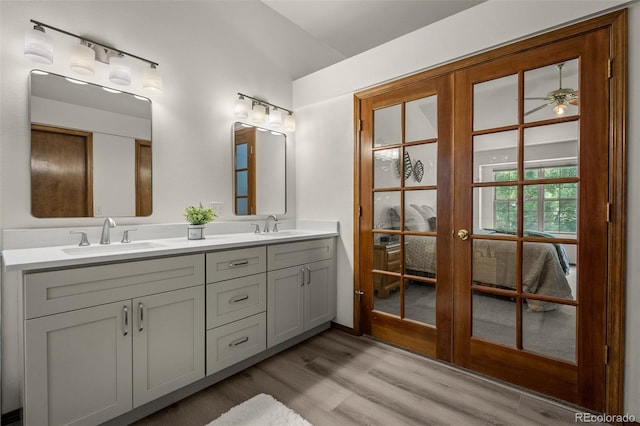6285 Moccasin Pass Ct, Colorado Springs, CO 80919 - full bath with french doors, double vanity, and wood finished floors