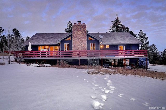 snow covered property with a wooden deck