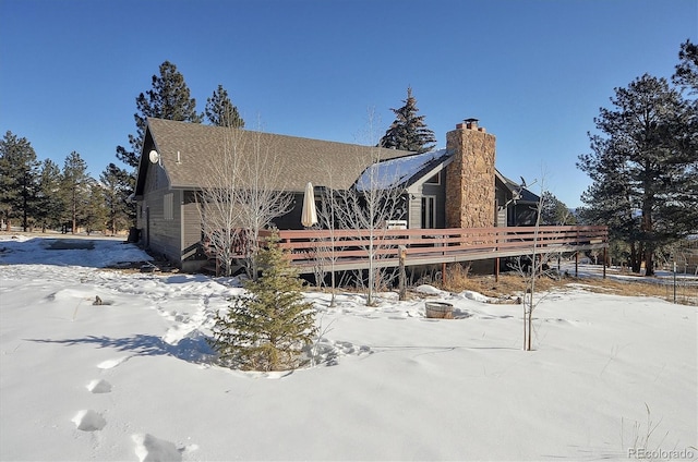 snow covered property with a deck