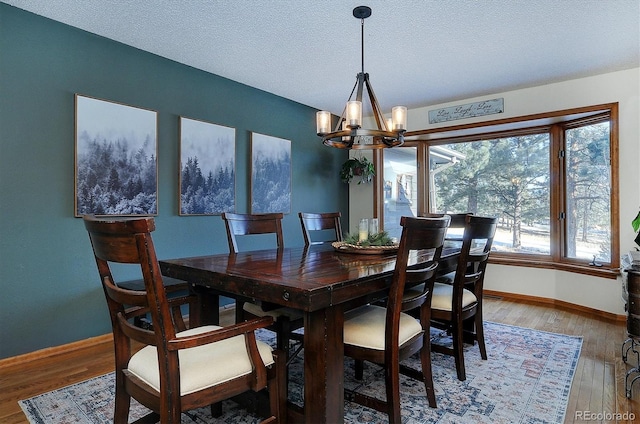 dining space with hardwood / wood-style flooring, a chandelier, and a textured ceiling