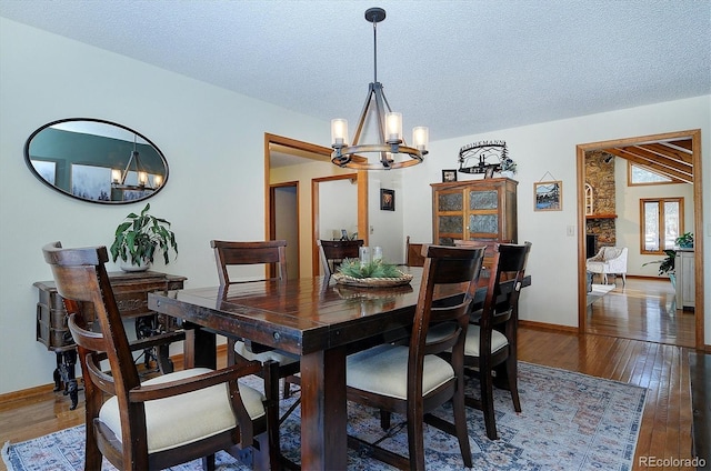 dining space featuring an inviting chandelier, hardwood / wood-style floors, and a textured ceiling