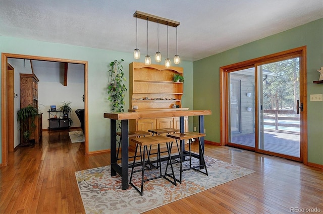 dining area featuring wood-type flooring and a textured ceiling