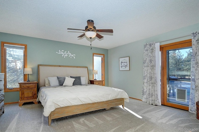 bedroom featuring ceiling fan, access to exterior, carpet, and a textured ceiling