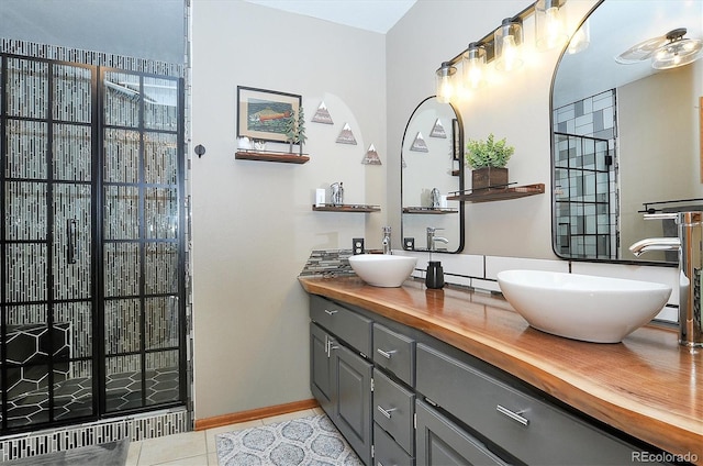 bathroom featuring tile patterned floors, vanity, and a shower