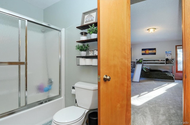 bathroom with toilet, bath / shower combo with glass door, and a textured ceiling