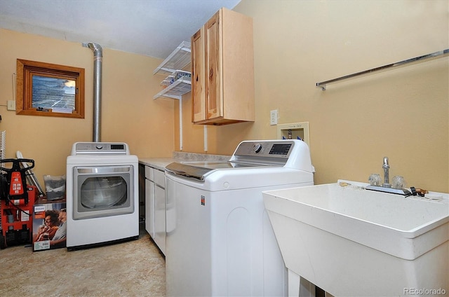 laundry room featuring sink, washing machine and dryer, and cabinets