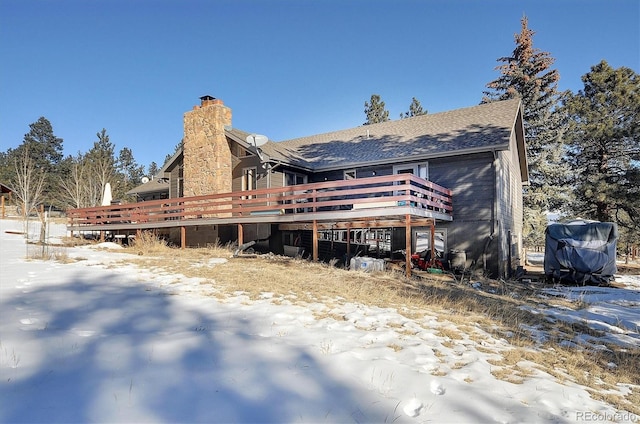 snow covered property with a wooden deck