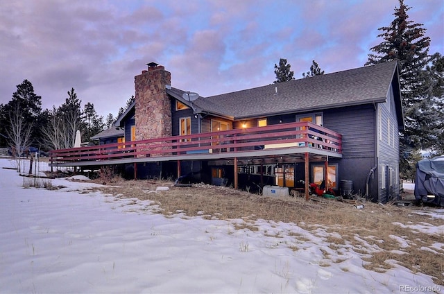 snow covered house with a deck