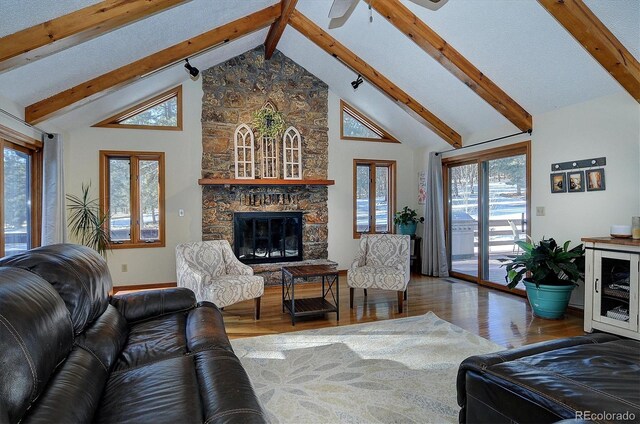 18360 Trail W Dr, Buena Vista, CO 81211 - living room featuring hardwood / wood-style floors, high vaulted ceiling, beam ceiling, a fireplace, and baseboards