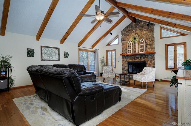 18360 Trail W Dr, Buena Vista, CO 81211 - living area with high vaulted ceiling, a stone fireplace, beam ceiling, wood finished floors, and a ceiling fan