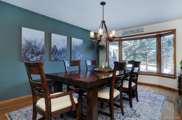 18360 Trail W Dr, Buena Vista, CO 81211 - dining room featuring a chandelier, baseboards, wood finished floors, and a textured ceiling
