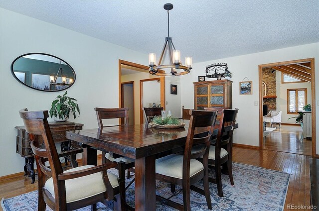 18360 Trail W Dr, Buena Vista, CO 81211 - dining room featuring a chandelier, wood finished floors, a textured ceiling, and baseboards