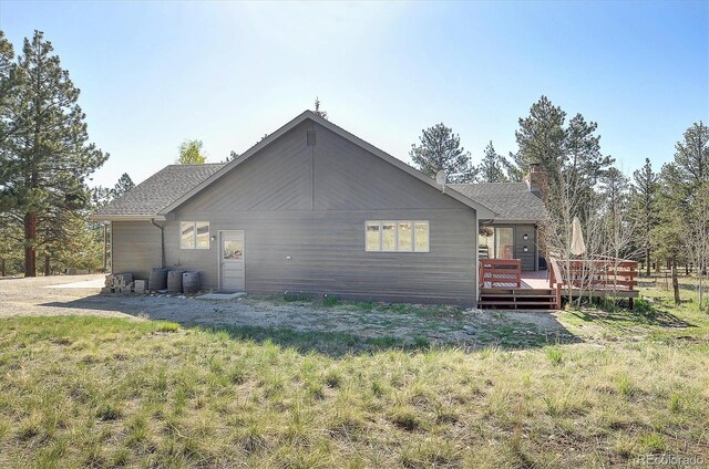 18360 Trail W Dr, Buena Vista, CO 81211 - view of side of home with a wooden deck, a chimney, and roof with shingles