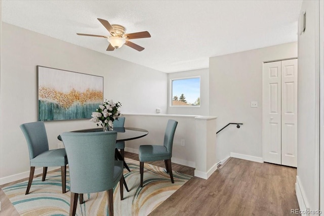 1488 S Andes Way, Aurora, CO 80017 - dining area featuring wood finished floors, a ceiling fan, and baseboards