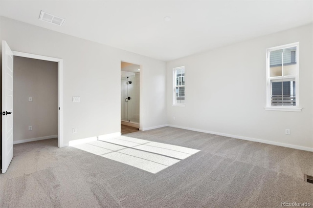 unfurnished room featuring light carpet