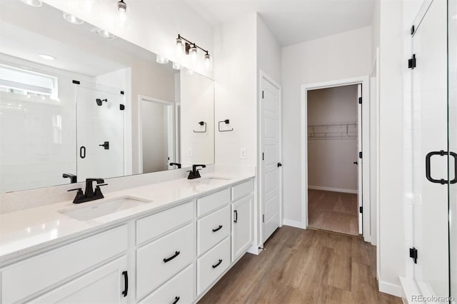 bathroom featuring wood-type flooring, an enclosed shower, and vanity