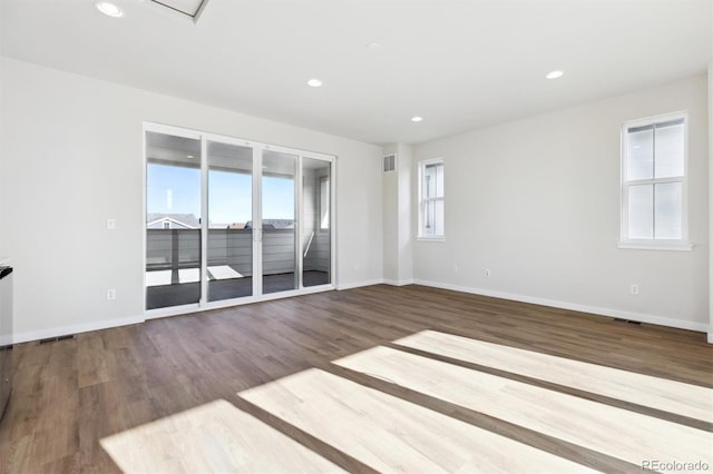 spare room featuring wood-type flooring and a wealth of natural light