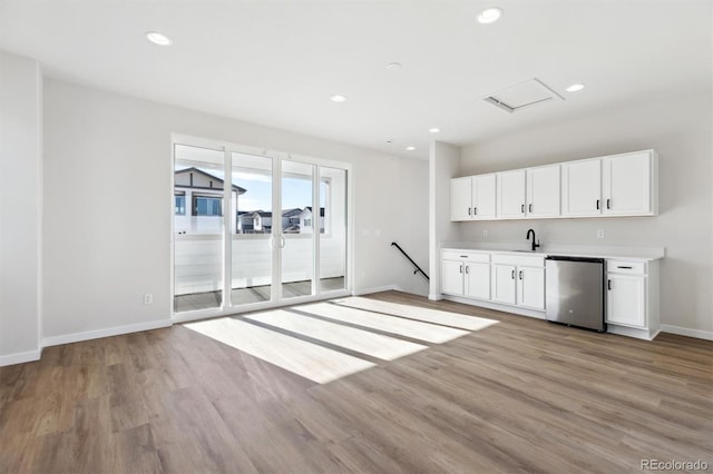 kitchen with white cabinetry, stainless steel dishwasher, sink, and light wood-type flooring