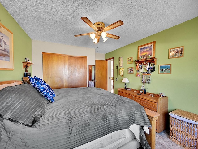 carpeted bedroom featuring ceiling fan, a closet, and a textured ceiling