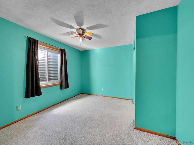 unfurnished room with ceiling fan, light carpet, and a textured ceiling