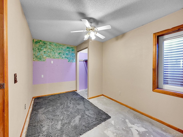 spare room with concrete flooring, a textured ceiling, and ceiling fan