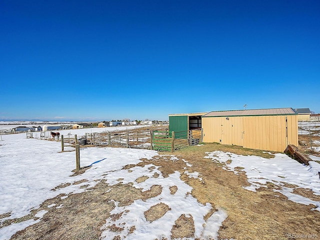 yard layered in snow with an outbuilding