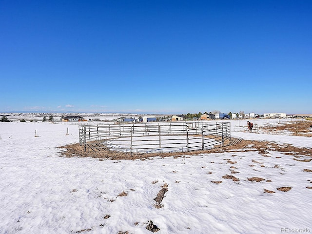 snowy yard with a rural view