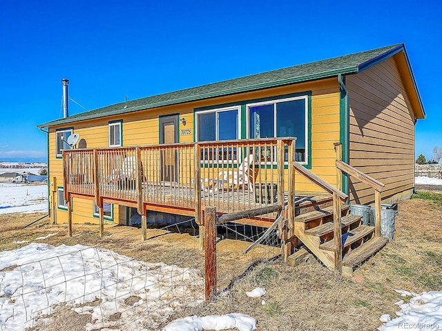 snow covered property with a deck