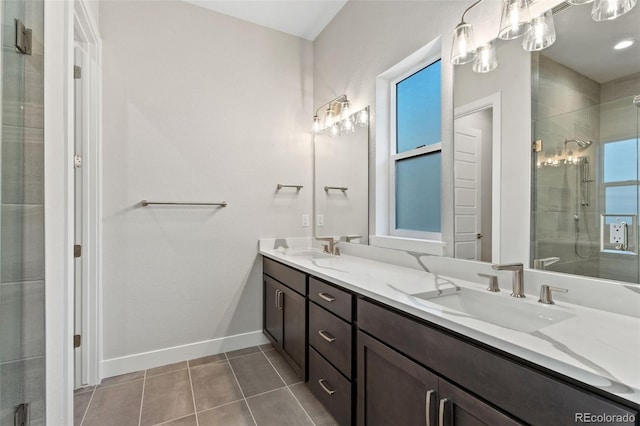 bathroom with a shower with shower door, vanity, and tile patterned floors