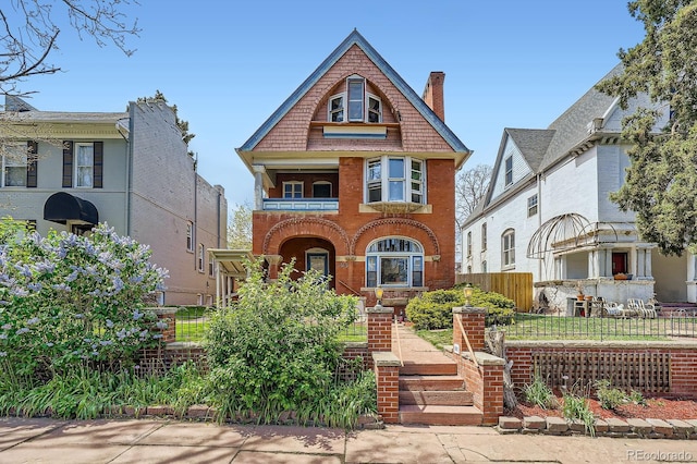 victorian home with brick siding and fence
